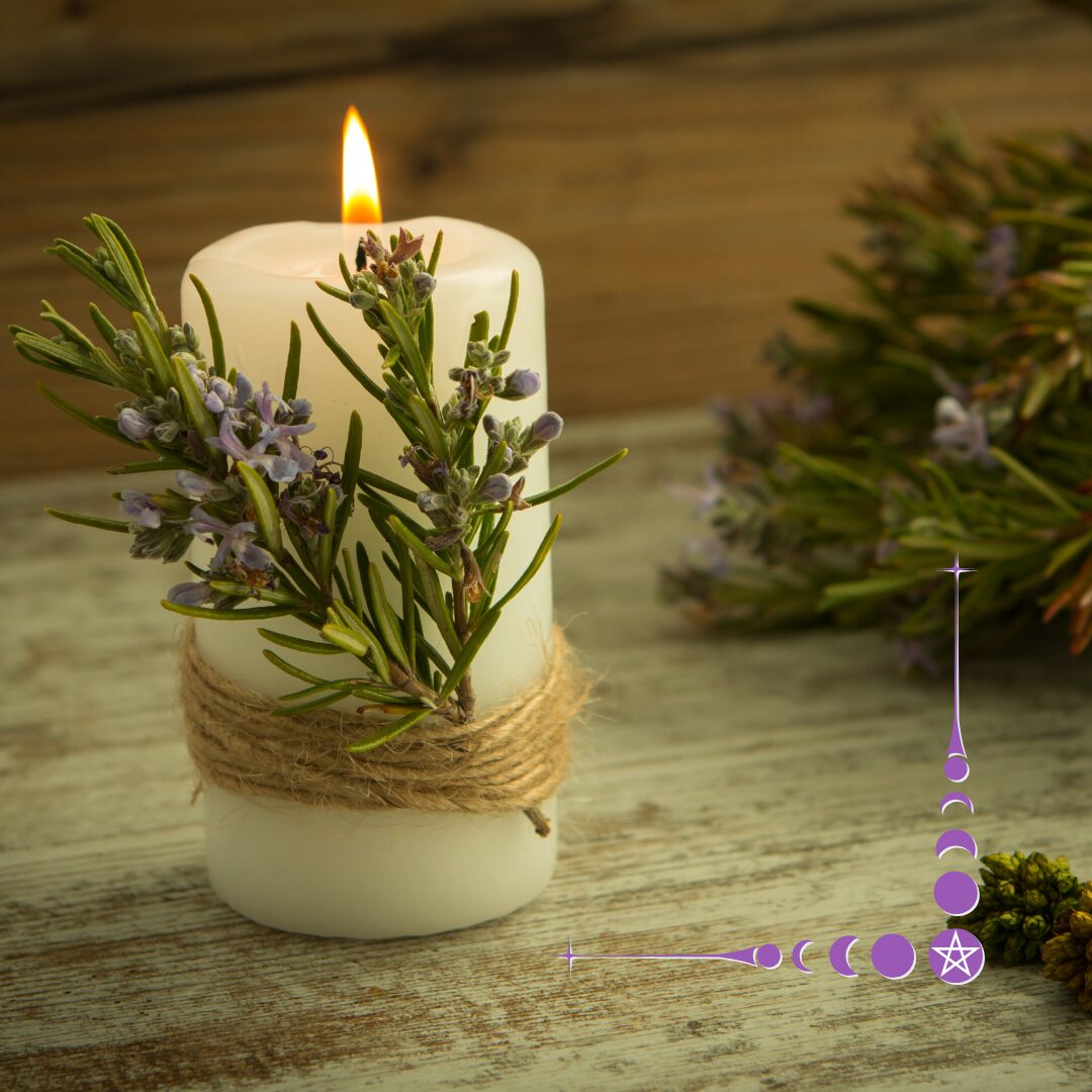 a lit white candle with a sprig of juniper with berries tied to it with hemp or jute twine. The candle sits on an aged looking wooden surface, with a large bunch of juniper branches in the background.