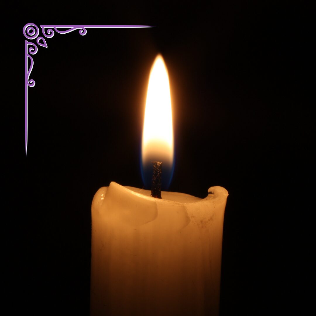 a single candle flame in darkness