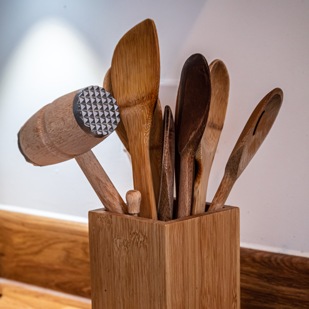 a bamboo container of wooden kitchen spoons