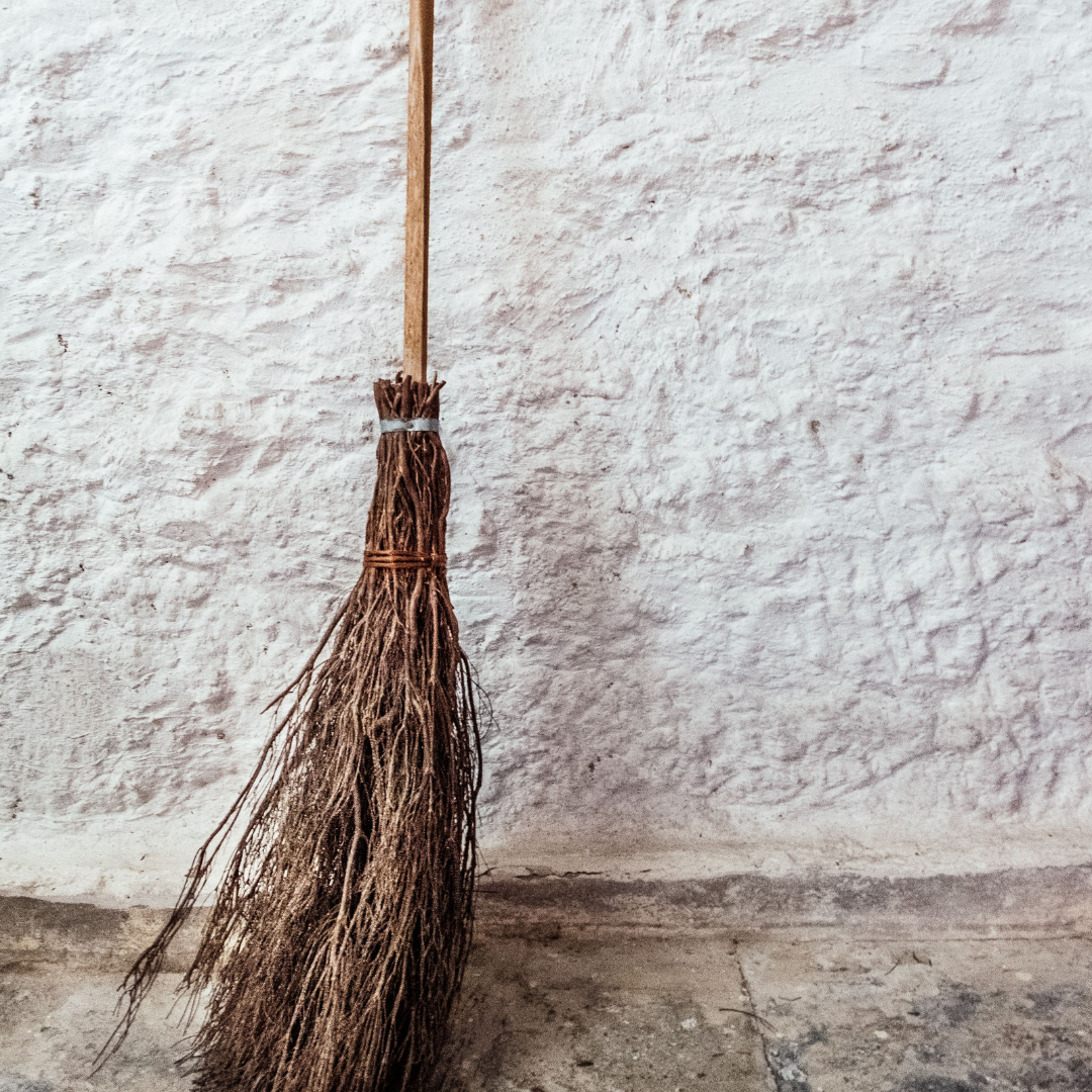 a broom of twigs leaning against a wall