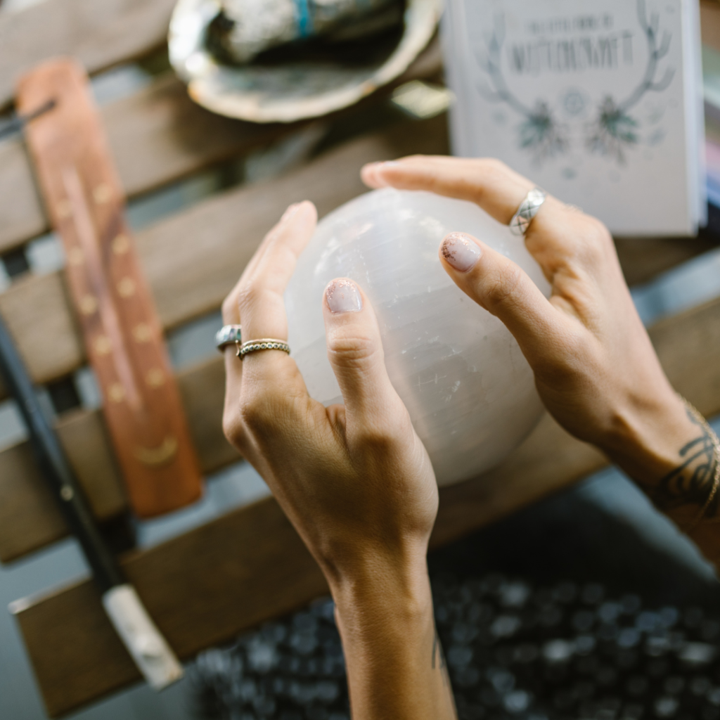 two hands grasp a crystal sphere
